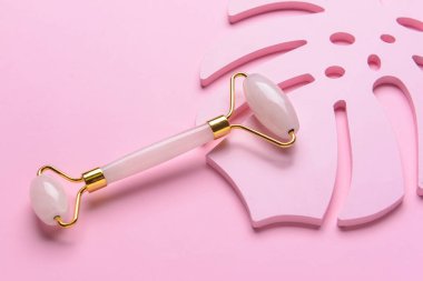 Renk arkaplanında yüz masajı silindiri