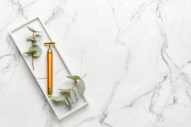 Beyaz arkaplanda yüz masajı silindiri