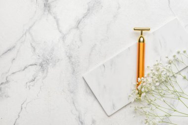 Beyaz arkaplanda yüz masajı silindiri