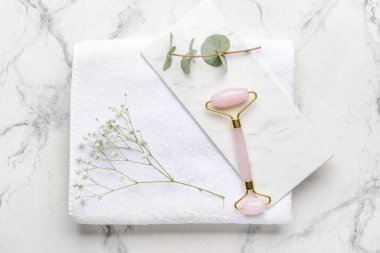 Beyaz arka planda havlusu olan yüz masajı silindiri