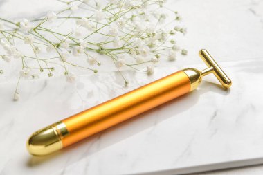 Beyaz arkaplanda yüz masajı silindiri