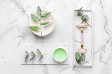 Beyaz arka planda kozmetik kremi olan yüz masajı silindiri