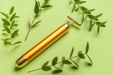 Renk arkaplanında yüz masajı silindiri