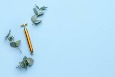 Renk arkaplanında yüz masajı silindiri