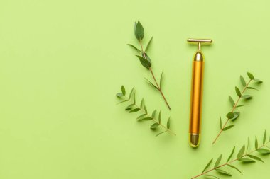 Renk arkaplanında yüz masajı silindiri