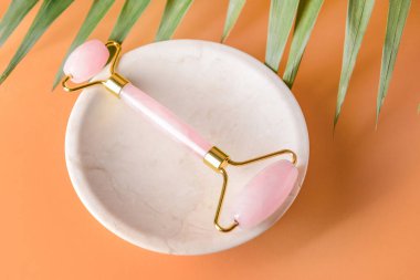 Renk arkaplanında yüz masajı silindiri