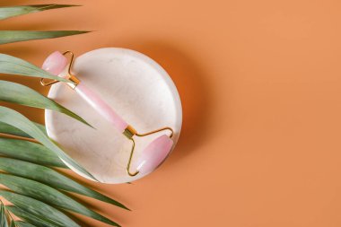 Renk arkaplanında yüz masajı silindiri