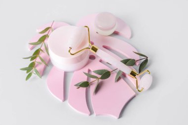 Hafif arka planda kozmetik ürünleri olan yüz masajı silindiri