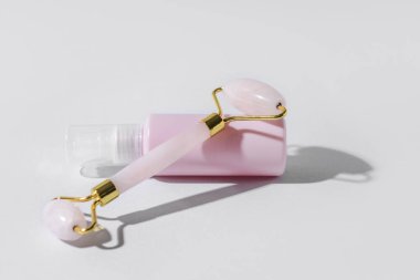 Hafif arka planda kozmetik ürünü olan yüz masajı silindiri