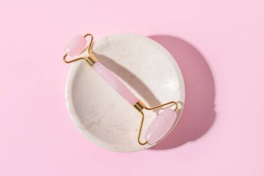 Renk arkaplanında yüz masajı silindiri