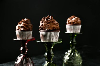 Koyu arkaplanda şarap bardakları olan lezzetli çikolatalı kekler.