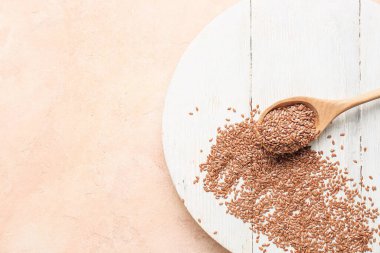 Arkaplanda keten tohumları olan tahta ve kaşık.