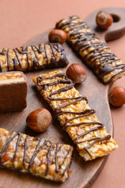 Renkli arkaplanda lezzetli çikolata çubukları olan tahta
