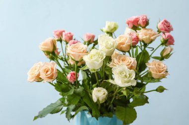 Renkli arkaplanda bir buket güzel gül olan vazo.