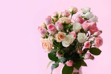 Üzerinde pembe arka planda bir buket gül olan vazo.