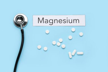 Stetoskop, haplar ve renk arkaplanı üzerine kelime MAGNESIUM