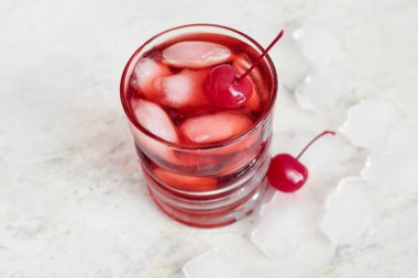 Hafif arka planda vişneli buzlu Manhattan kokteyli. Yakın plan.