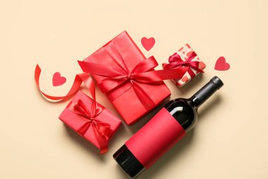 Hafif arka planda hediyeleri olan bir şişe şarap.