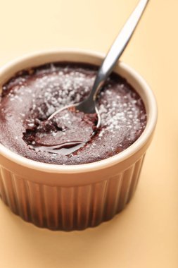 Bej arka planda lezzetli lav keki olan Ramekin, yakın plan.