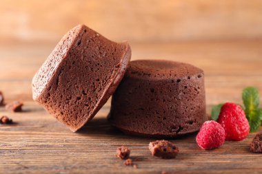 Lezzetli lav keki şekeri ve ahududu ahşap arka planda, yakın plan.