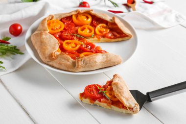 Hafif ahşap arka planda lezzetli bir domates galeti tabağı.