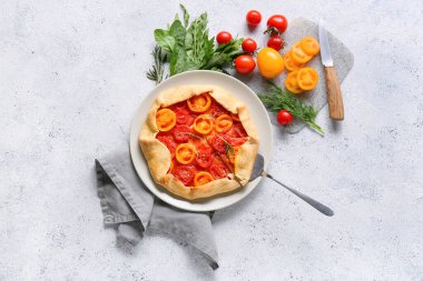 Açık arkaplanda lezzetli domates galetesi olan bir tabak.