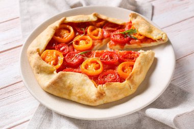 Açık ahşap zemin üzerinde leziz domates galeti tabağı, yakın plan.