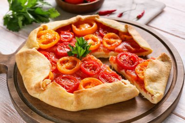 Hafif ahşap arka planda leziz domates galeti olan tahta, yakın plan.