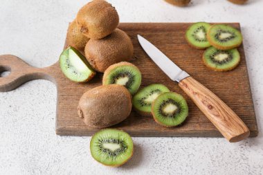 Açık arkaplanda taze kesilmiş kivi olan tahta