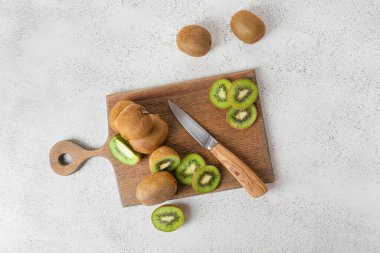 Açık arkaplanda taze kesilmiş kivi olan tahta