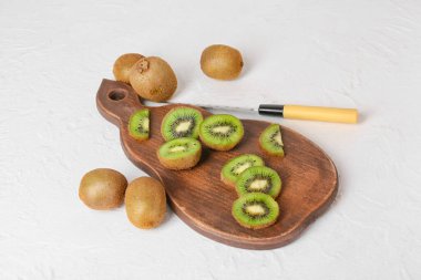 Açık arkaplanda taze kesilmiş kivi olan tahta