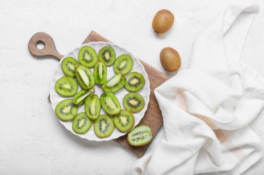 Açık arkaplanda taze kesilmiş kivi tabağı