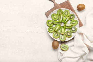 Açık arkaplanda taze kesilmiş kivi tabağı