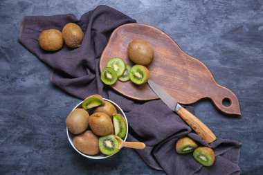 Koyu arkaplanda taze olgun kivi olan bir kase.