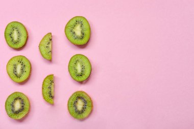 Pembe arka planda taze kesilmiş kivi