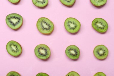 Pembe arka planda taze kesilmiş kivi