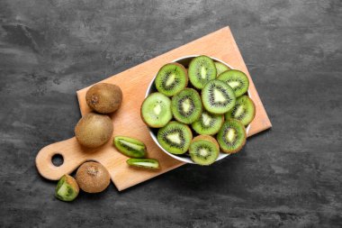 Koyu arkaplanda taze kesilmiş kivi kasesi.