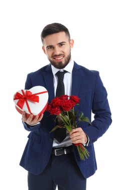 Beyaz arka planda kız arkadaşına hediye ve çiçek getiren yakışıklı bir genç. Sevgililer Günü kutlaması