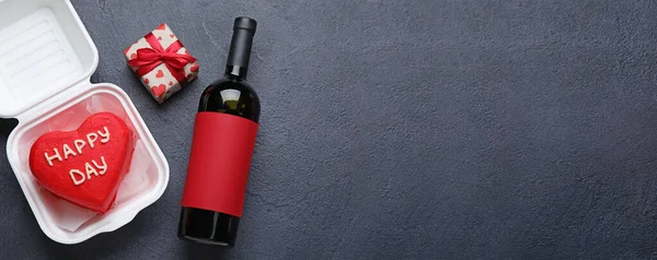 Lezzetli bento keki ve Sevgililer Günü hediyesi. Karanlık arka planda bir şişe şarap ve mesaj için yer var.