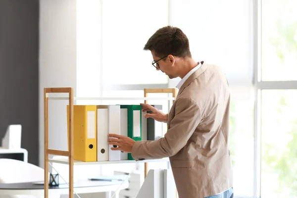 Young Man Taking Folder Shelf Office — Foto de Stock