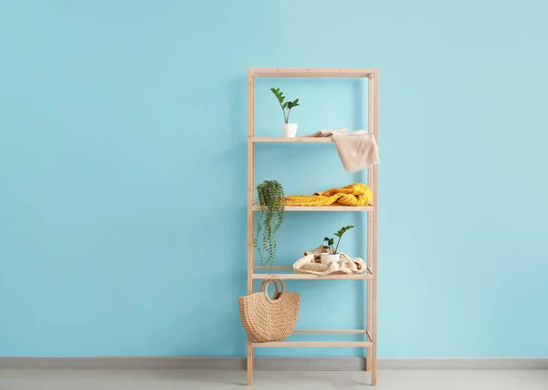 青い壁の近くの植木鉢と木製の棚ユニット — ストック写真