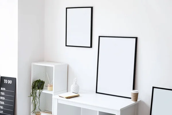 Blank frames in interior of light modern room