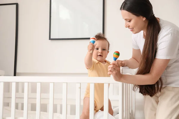 Mladá Matka Dává Hračky Pro Své Malé Dítě Postýlce Doma — Stock fotografie