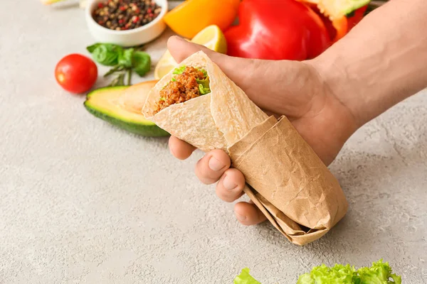 Man Holding Tasty Burrito Light Background Closeup — Stock Photo, Image