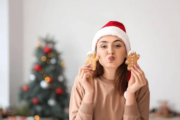 Happy Young Woman Santa Hat Gingerbread Cookies Blowing Kiss Home — Stock Photo, Image