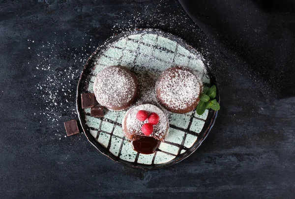 Lezzetli lav keki şekerlemeli tabak ve koyu arkaplanda ahududu.