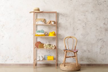 Aksesuarlı raflar, sandalye ve pouf ışıklı duvarın yanında.