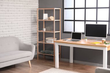 Çalışma yeri ve raf ünitesi olan modern odanın içi