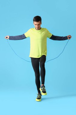 Sportif genç adam renk arkaplanda ip atlıyor