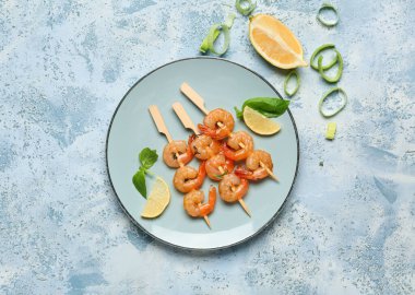 Mavi arka planda ızgara karides şiş tabağı